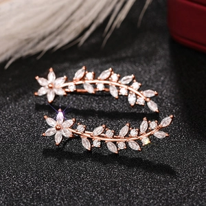 Macro shot of rose gold vine ear crawlers with sparkling white zircon flower and leaf details
