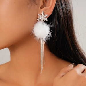 Detail of snowflake earrings with rhinestones, white pom pom and silver tassels on model