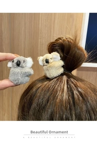 Close-up of cute plush koala hair clip with fluffy grey faux fur and soft texture details