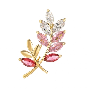 Leaf-shaped gold brooch with emerald teardrop zircon and colorful sparkling crystals