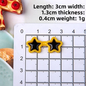 Macro view of 3cm yellow star shaped doll sunglasses on a white measurement grid
