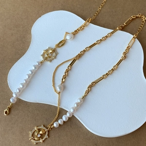 Detailed close-up of a gold pearl necklace featuring a diamond-set rose pendant