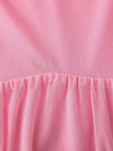 Detailed close-up of pink mesh fabric with elegant pleated texture and soft drape