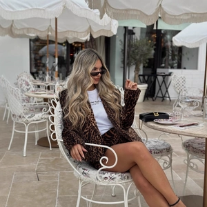 Women's leopard print blazer and shorts suit set with white graphic tee on a model