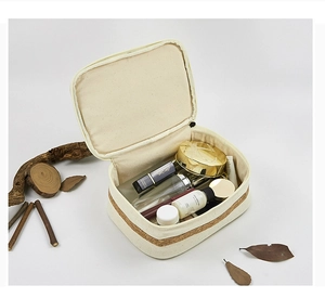 Detailed view of an open cotton canvas makeup bag with cork base and natural decor