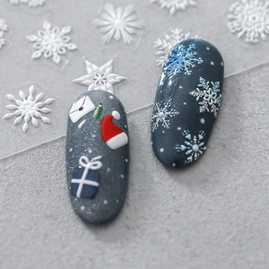 5D embossed Christmas nail stickers with 3D snowflakes and hats on blue glitter nails