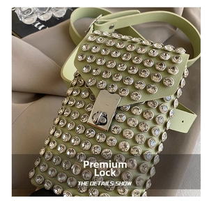 Detail view of premium silver twist lock on light green rhinestone shoulder bag