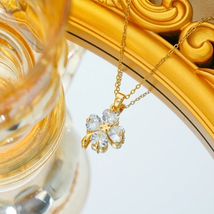 Elegante Kleeblatt-Halskette aus Gold-Titanstahl mit herzförmigem Zirkon auf Spiegel