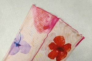 Gros plan sur tissu mesh fleuri avec détails de couture ourlet ondulé rose vif