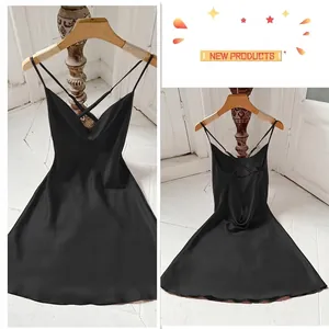 Elegant black silk slip dress featuring delicate cross back straps and a fluid silhouette