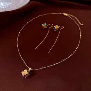 18K gold plated cat eye stone necklace and earrings set on dark brown velvet backdrop