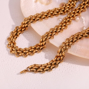 Macro view of gold-plated multi-layer heavy link necklace on a seashell disk