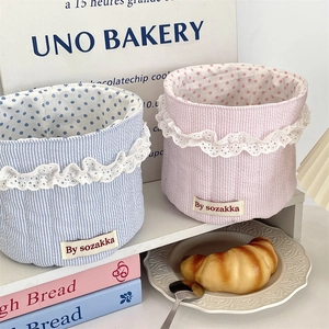 Detailed view of quilted fabric storage baskets with lace trim and polka dot lining