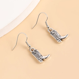 Vue détaillée des boucles d'oreilles bottes de cowboy argentées au style punk rétro