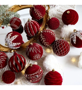 Close-up of red flocked Christmas balls with pearls and gold glitter on white knit