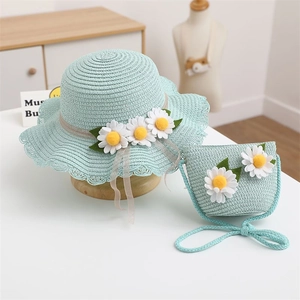 Detail of mint green straw hat and matching crossbody bag with white daisy flowers