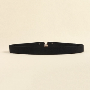 Detail of black elastic waist belt with textured stretch fabric and gold metal buckle
