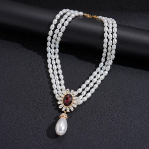 Détail du collier de perles à trois rangs avec pendentif rubis et perle poire
