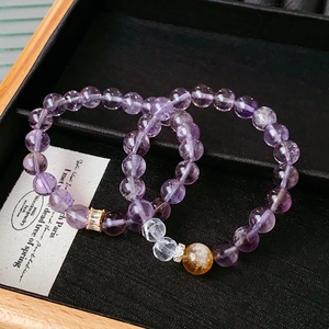 Macro detail of purple amethyst bead bracelet set with golden zircon accents in a gift box