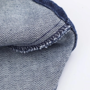 Vue macro détaillée de la texture du denim bleu foncé et des finitions de couture premium