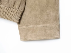 Detail der khakifarbenen Wildlederstruktur mit verstärkten Nähten und plissiertem Saumdesign