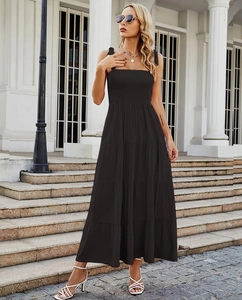 Détail du bustier froncé et des bretelles de cette robe longue noire à volants