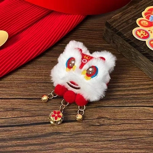 Détail d'une pince à cheveux lion de danse en peluche blanche avec pompons et grelots