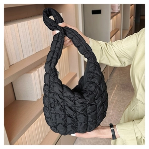 Detail of black quilted cloud bag showing the large square stitching and nylon texture