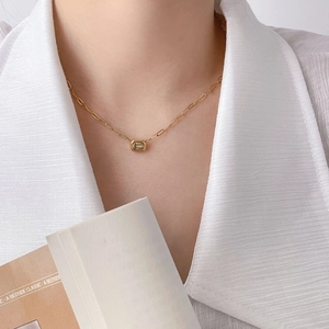 Detail of 18K gold-plated necklace with a rectangular zircon pendant on a model