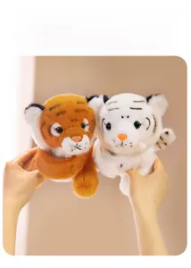 Detailed view of yellow and white tiger plush slap bracelets held in hands