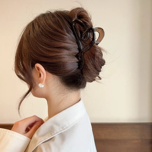 Detail of large brown tortoiseshell claw clip worn on model for an elegant hairstyle