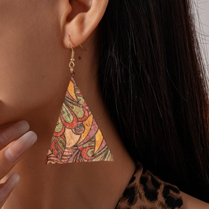 Gros plan de boucles d'oreilles triangulaires en cuir avec imprimé abstrait sur mannequin
