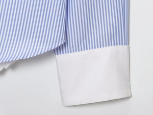 Detailaufnahme des blau gestreiften Stoffes mit kontrastierenden weißen Hemdmanschetten