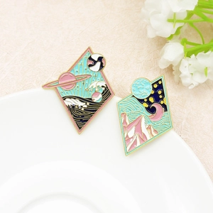 Enamel diamond-shaped brooches featuring space ocean and starry mountain landscape