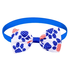 Close-up of Independence Day dog bowtie with American flag paw print on blue ribbon