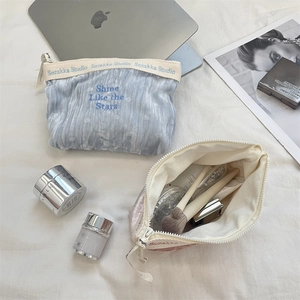 Dettaglio della trousse in velluto azzurro con ricami e astuccio per pennelli da trucco