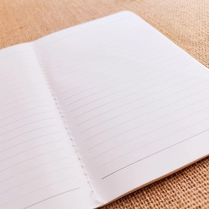 Detailopname van de duurzame stikbinding op minimalistische wit gelinieerde notitiepagina's