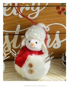 Close-up of plush snowman Christmas ornament with wooden buttons and red scarf