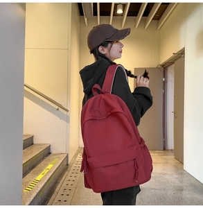 Detailansicht eines roten Rucksacks mit großem Fassungsvermögen und dekorativem Webband