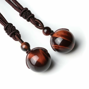 Détail macro de perles en œil de tigre rouge naturel sur un collier tissé à la main