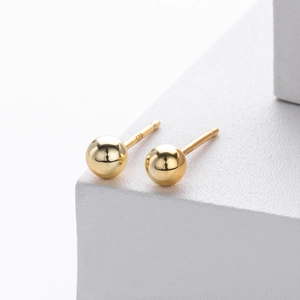 Macro shot of polished gold-plated S925 sterling silver bead earrings with S925 hallmark