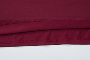 Close-up of wine red knit fabric showing neat double-needle stitching and texture