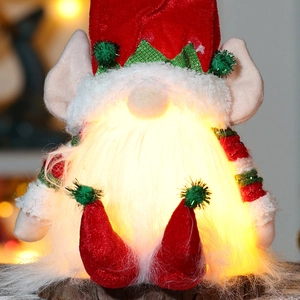 Close-up of a glowing Christmas gnome with warm LED lights and a red knitted hat