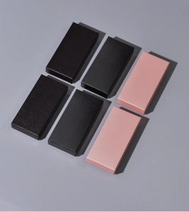 Macro shot of rectangular gift boxes in black and pink with subtle paper texture detail