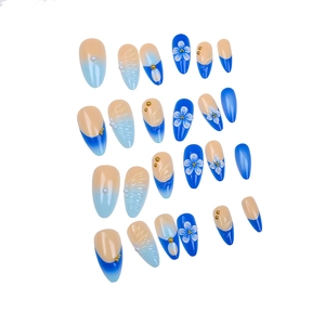 Dettaglio di unghie a mandorla con sfumatura blu, fiori 3D, perle e texture a conchiglia