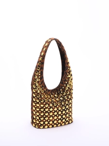 Close-up of brown leopard print texture with polished gold metal rivets on the bag