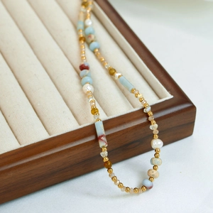 Macro detail of natural pearls and colorful crystal beads on a stainless steel necklace