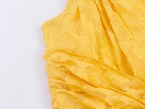 Macro shot of yellow floral jacquard fabric showing intricate texture and weave detail