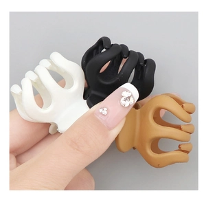 Close-up of matte hair claw clips in ivory, black, and brown for elegant hair styling