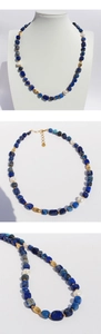 Detail of lapis lazuli beads and baroque pearls on a gold-tone layered necklace